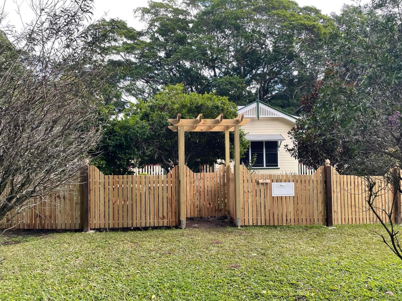 Timber picket fence with arbor